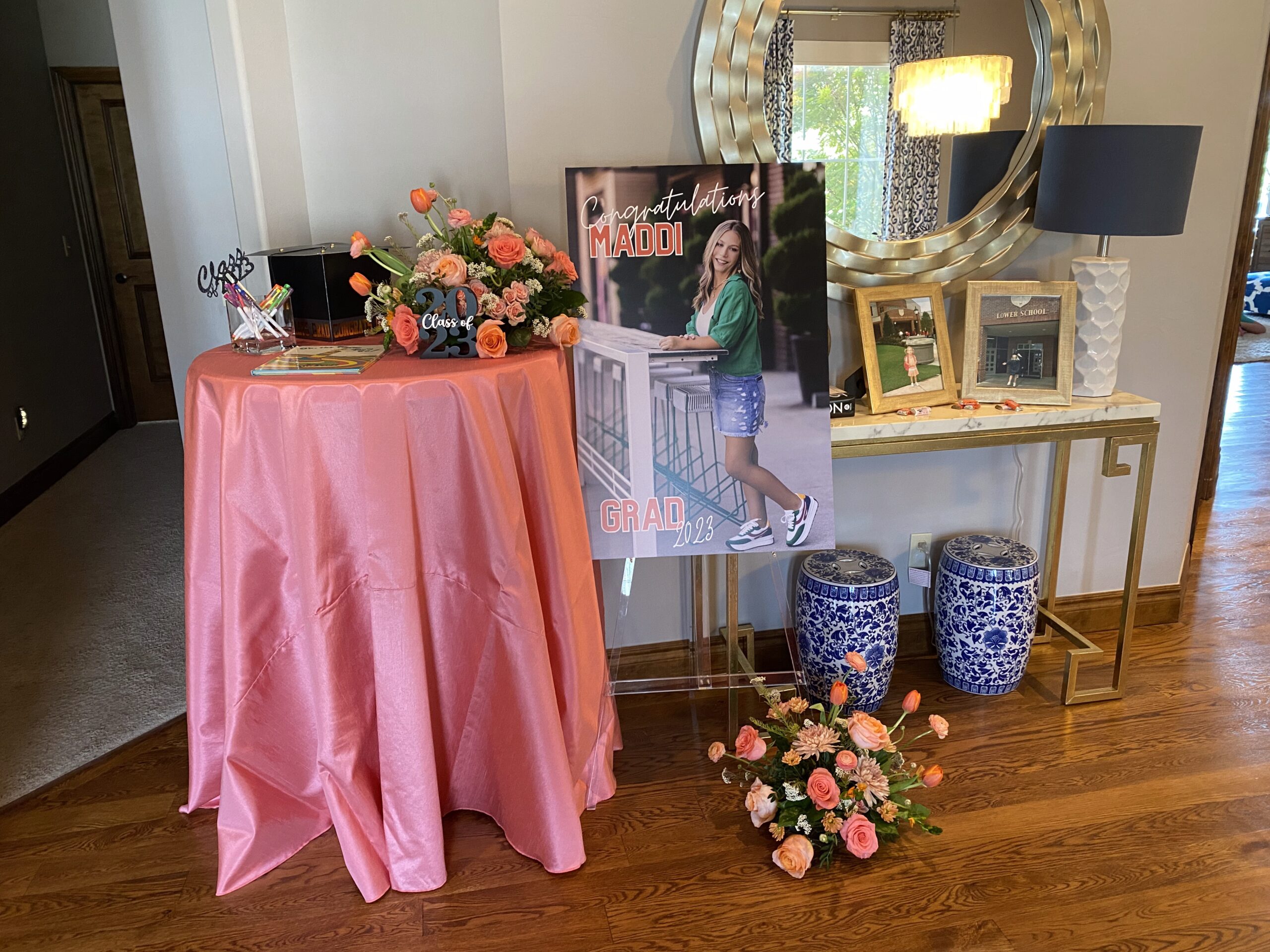 Private event welcome station with photos and sign in book on table with pink tablecloth and pretty bouquets. Cultivate Event Planning Private Event Planner OKC